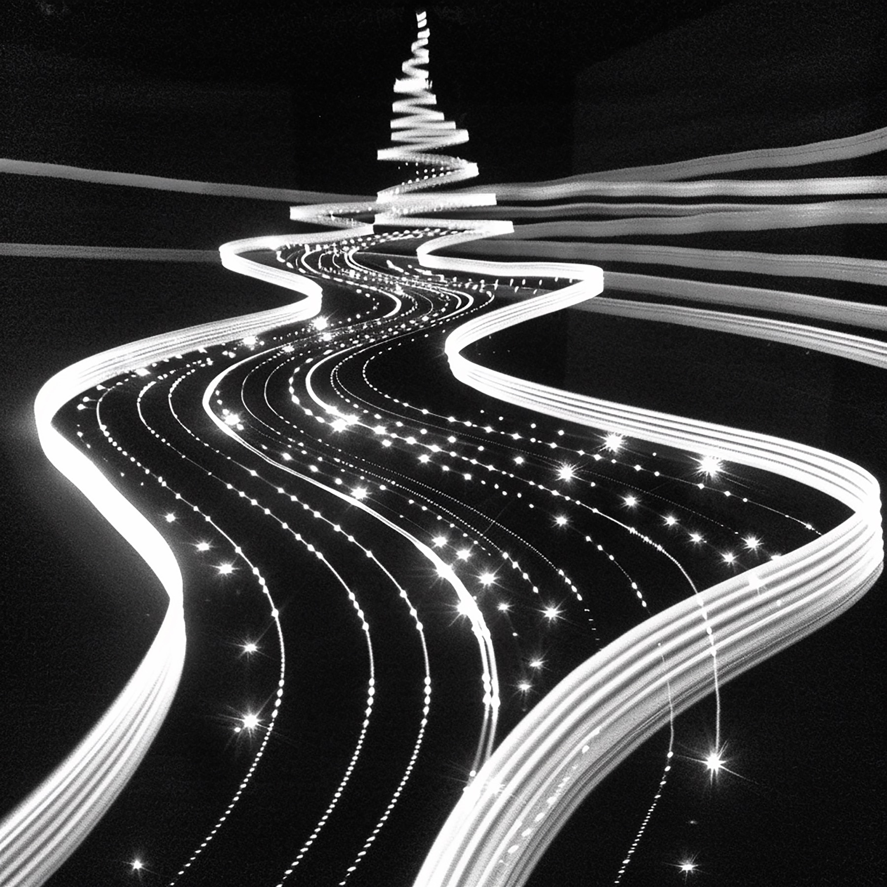 Monochrome light paths flowing together through a dark landscape
