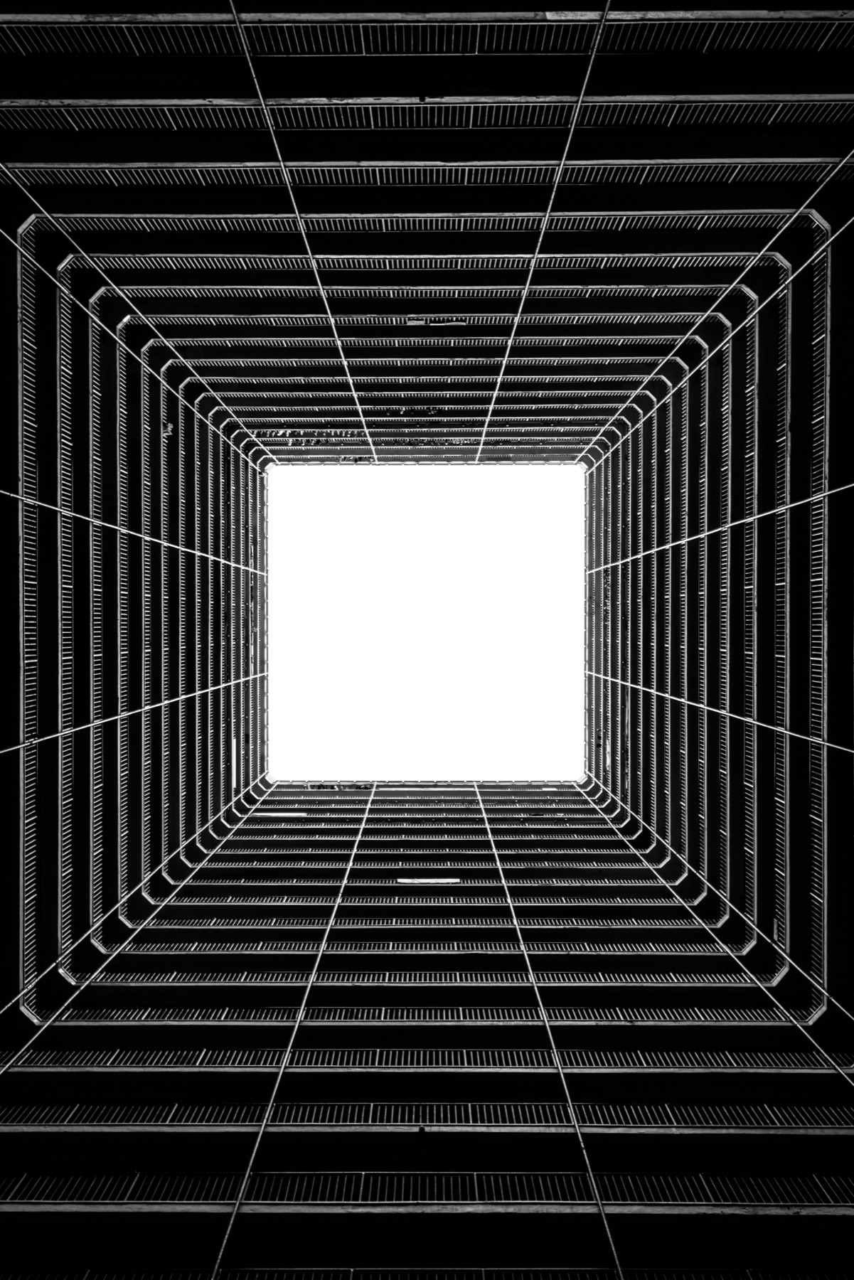 Monochrome architectural courtyard rising toward an open skylight